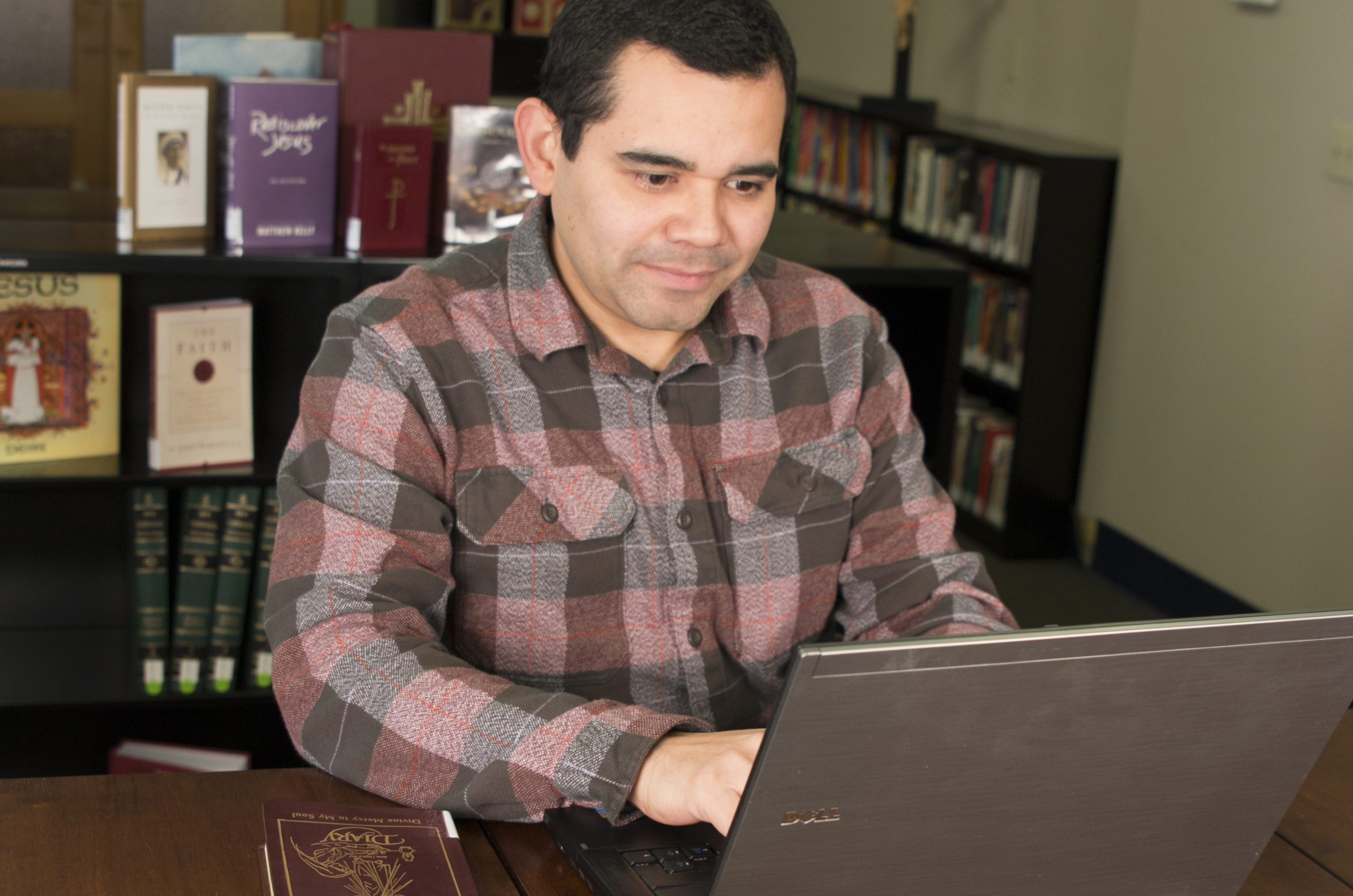 Edwin Ferrera on the computer in the Chancery Library Media Center, November 20, 2015. Books, Janis Olson Photography.